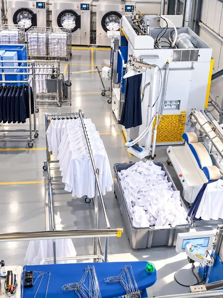 Steam finishing station with dress shirts and suiting prepared for customers